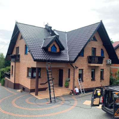 Praca przy malowaniu dachu