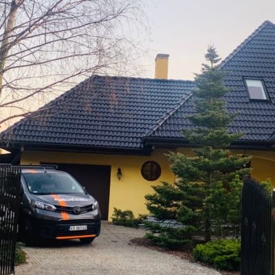 Pomalowany dach z dachówki betonowej oraz samochód Biotop